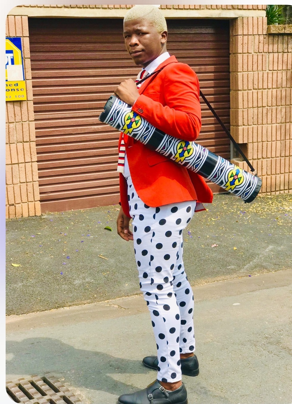 Turnup customer in red blazer carrying a Ndebele-patterned tower speaker